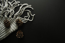 blanket and pine cones on black 