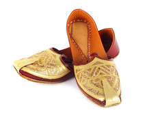 Pair of traditional Indian shoes on white background