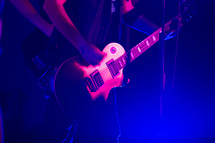 musician on stage playing an electric guitar 