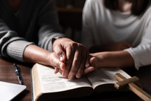 Women praying on Bible