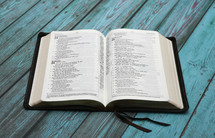 open Bible on blue wood boards 