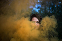 a woman standing behind smoke 