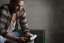 man holding a Bible sitting in thought 