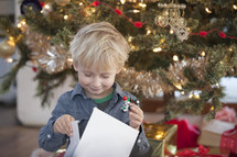 A child opening a Christmas present Christmas morning. 