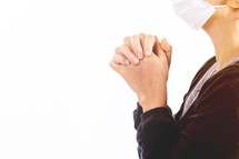 woman praying wearing a mask 