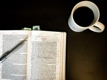 coffee mug and open Bible with notes on the pages 
