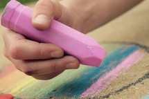 a little girl drawing with sidewalk chalk close up 