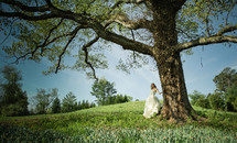 bride standing under a tree