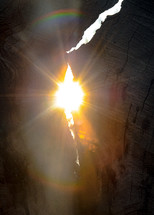sunburst through crack in a rock cave 