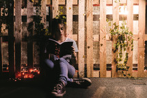 a teen girl sitting quietly and reading 