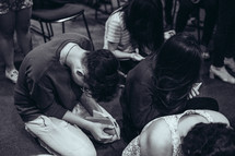 kneeling in prayer during a worship service 