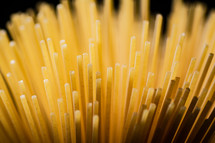 A pile of spaghetti dry on the table. Against a dark background. High quality photo