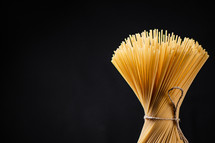 A pile of spaghetti dry on the table. Against a dark background. High quality photo