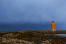 orange lighthouse and cloudy sky