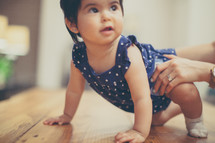 infant girl learning to crawl 