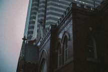 brick church and skyscraper in a city 