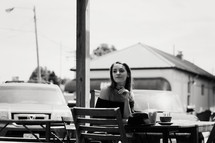 woman sitting iced coffee and cappuccino on a wooden table outdoors 