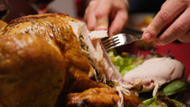 Man cutting roasted Chicken with knife for thanksgiving day in home