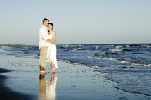 couple standing in the tide of the ocean