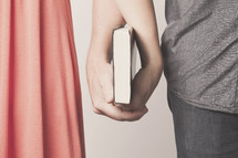 husband and wife holding a Bible together