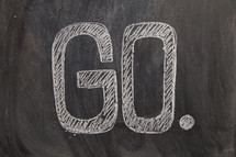 the word go written on a black chalkboard. missions concept. 