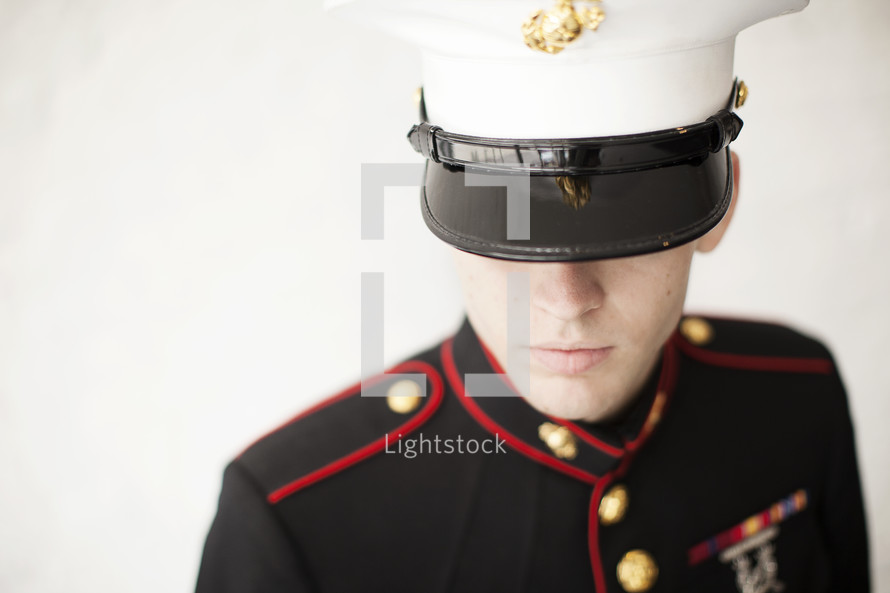Marine in uniform looking down.