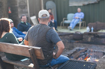 people sitting around talking at an outdoor gathering 