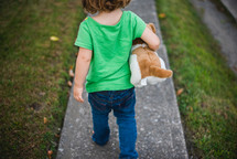 a girl walking with a stuffed animal 