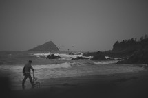 a man walking his dog along a beach shore 