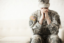 Female soldier in uniform praying.