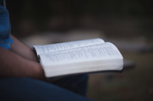 Holding an open Bible.