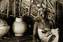African woman in her hut  by her pottery