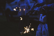 people holding sparklers at night 