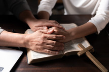 Women praying on Bible