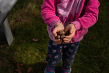 child holding acorns 