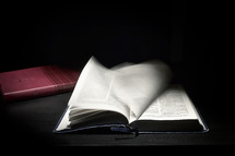 Open Holy Bible Moving Pages on Dark Background