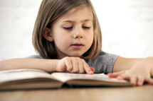 young kid reading a book.