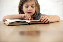 girl reading a children's Bible 