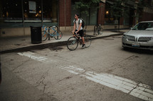 A young man riding a bicycle down a city street.