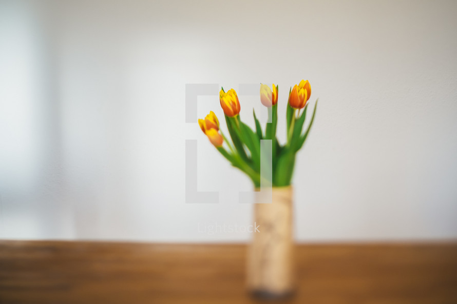 orange and yellow tulips in a vase 