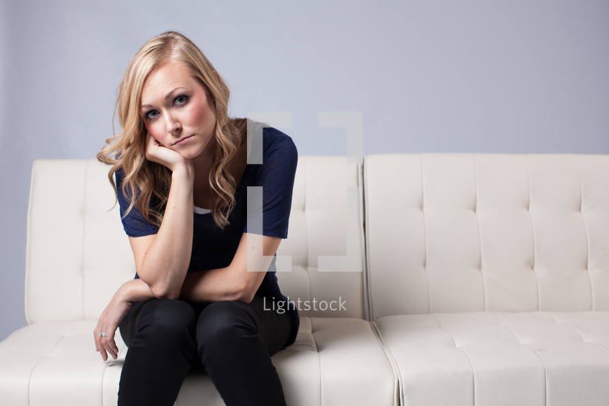 woman pouting on a white couch 