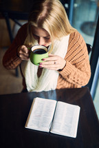 a woman reading a Bible and drinking coffee