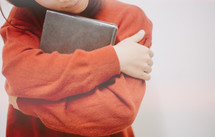 a woman hugging a Bible 