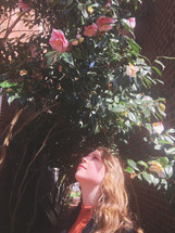 a woman looking up at pink flowers 