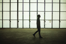 a man walking in an empty warehouse 