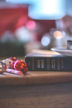 a Bible on a table next to Christmas decorations 