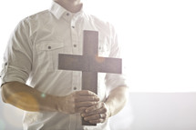 man holding a cross in front of his chest
