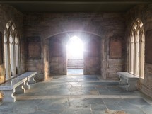 sunlight through the open doors of a stone chapel 