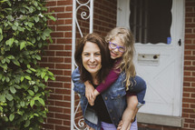 mother and daughter standing in front of a front door 