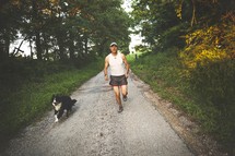 A man jogging with his dog. 